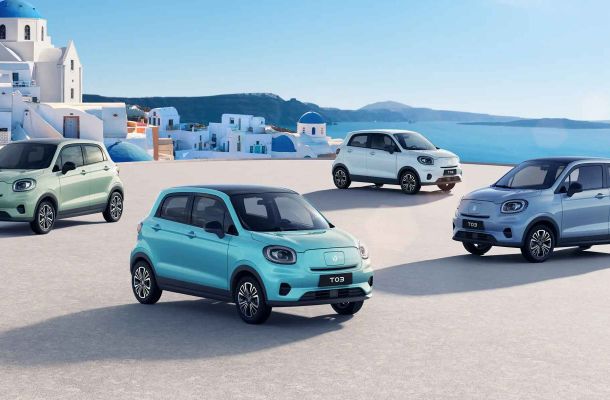 Four colorful Leapmotor T03 electric cars parked by a coastal town.