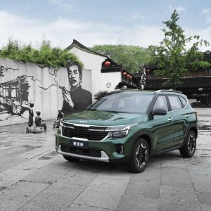 KIA Seltos 2023 1.5L CVT Premium Edition gallery4 A green Kia Seltos SUV in a square with traditional Chinese murals and sculptures.