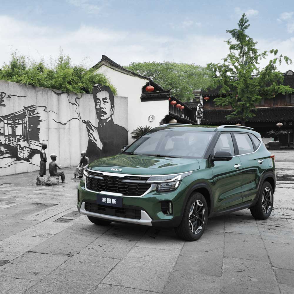 KIA Seltos 2023 1.5L CVT Premium Edition gallery4 A green Kia Seltos SUV in a square with traditional Chinese murals and sculptures.