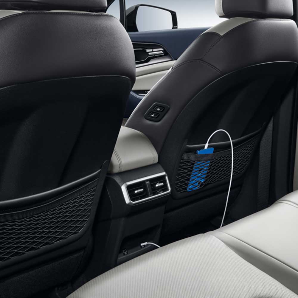 KIA Sportage 2025 1.5T 2WD Premium Intelligent Edition usb Interior of a car showing rear seat area with charging ports and a phone in a mesh pocket.