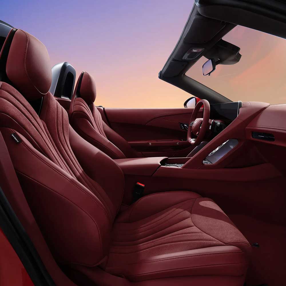 Interior of a car with red leather seats and a convertible roof.