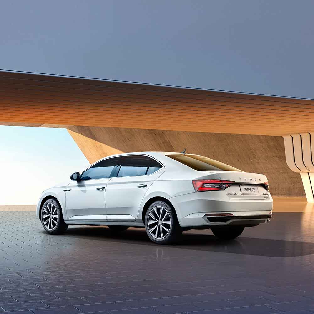 Rear view of a white Škoda Superb sedan.