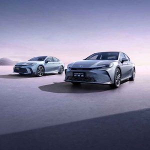 Two Toyota Camry sedans displayed in an open space under a gradient sky.