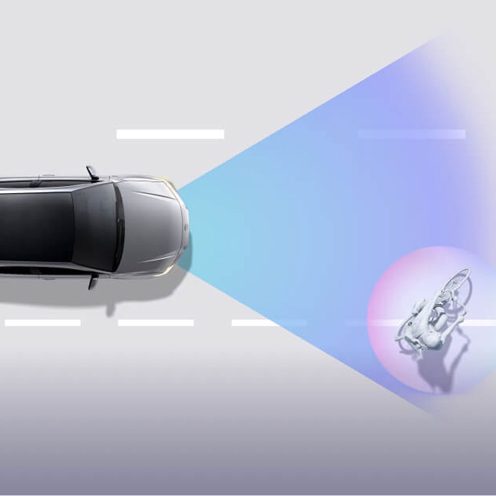 A car with a detection system identifying a cyclist on the road.