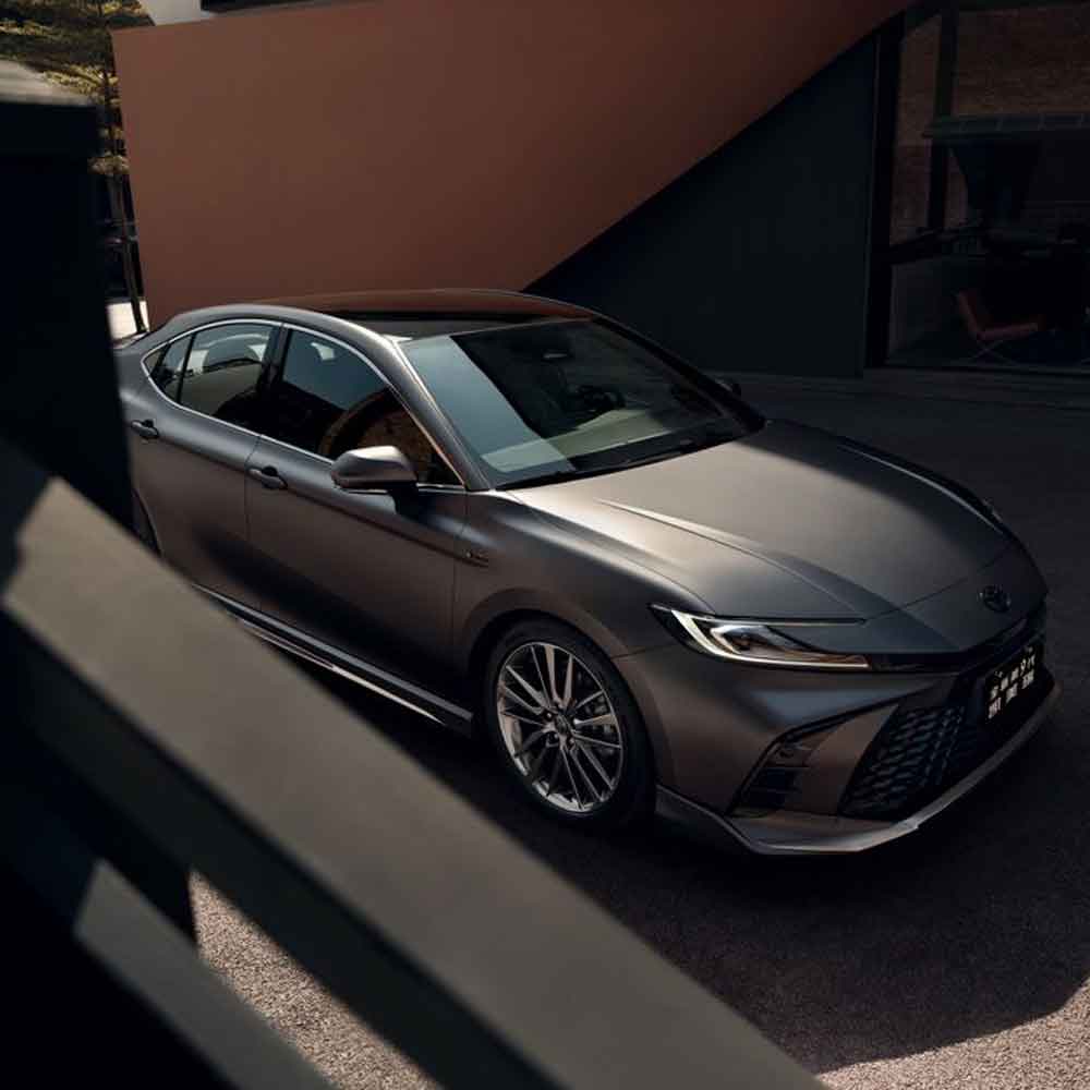A sleek gray Toyota sedan parked near a modern building.