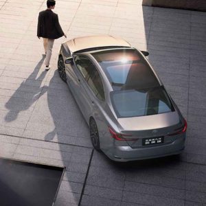 A man walking towards a silver Toyota Camry with a panoramic sunroof, viewed from above.