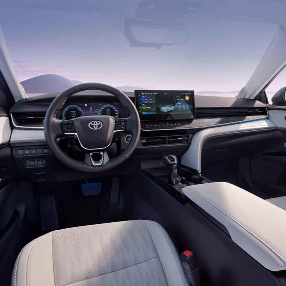 The interior of a Toyota car, showcasing the steering wheel, dashboard, and infotainment screen.