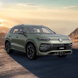 VW-All-New-Tayron-L-2025-300TSI-2WD-Elite A green Volkswagen Tayron L SUV parked on a scenic mountain road at sunset.