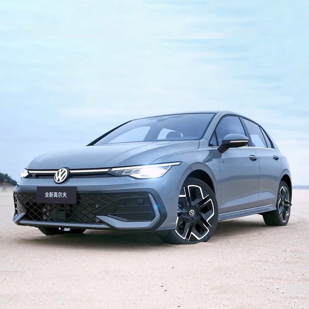 A gray Volkswagen Golf parked on sandy ground under a clear sky.