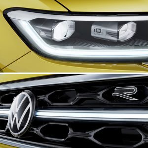 Close - up of a yellow Volkswagen's headlight with IQ.LIGHT and front grille with the Volkswagen logo and "R" emblem.