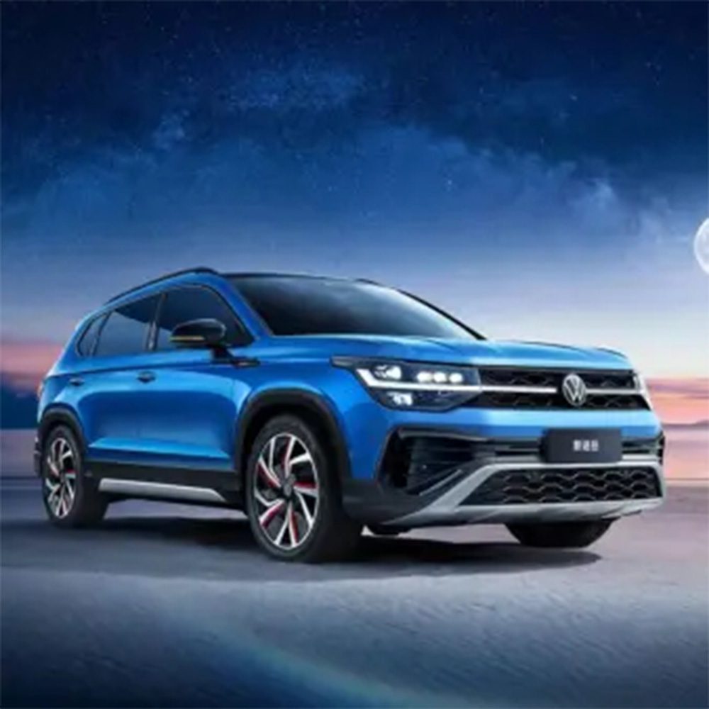 A blue Volkswagen SUV under a starry night sky with a moon.