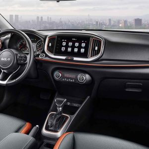 Interior view of a Kia car with a central display screen and gear shift.