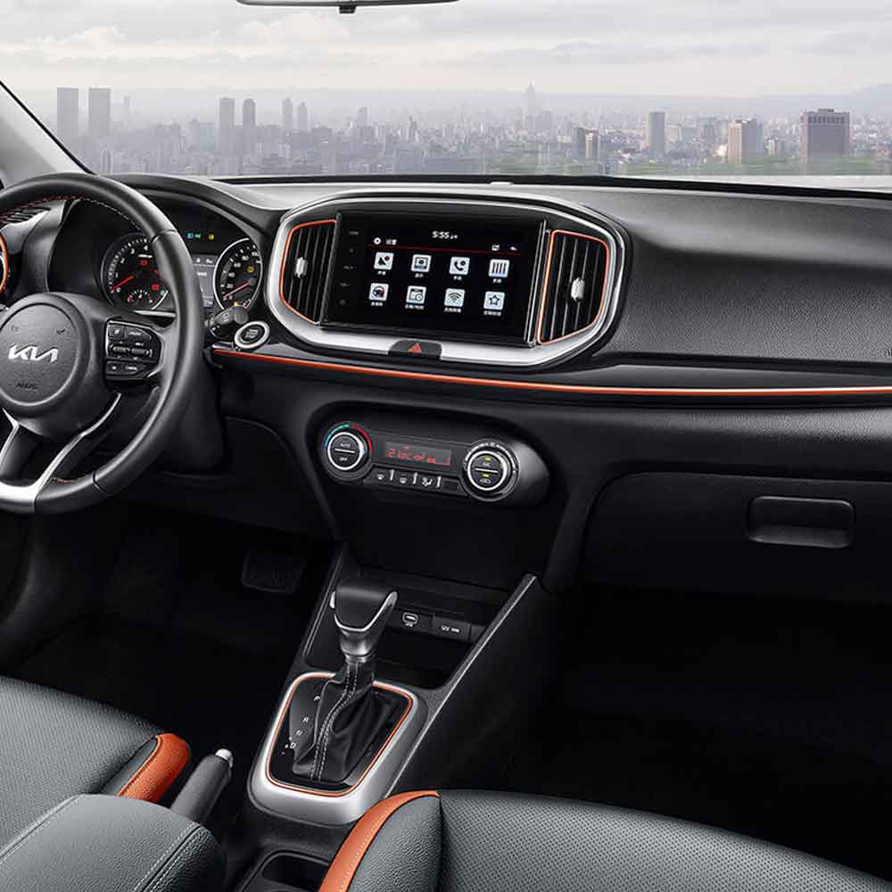 Interior view of a Kia car with a central display screen and gear shift.