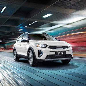 A white Kia Stonic driving at high speed with motion blur.