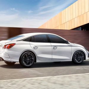 White sedan driving in urban setting.