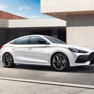 White sedan driving in urban setting.