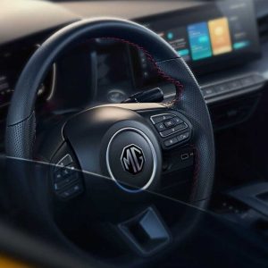 MG car steering wheel with logo and infotainment screen.