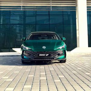 A green MG7 car parked in front of a modern glass building.