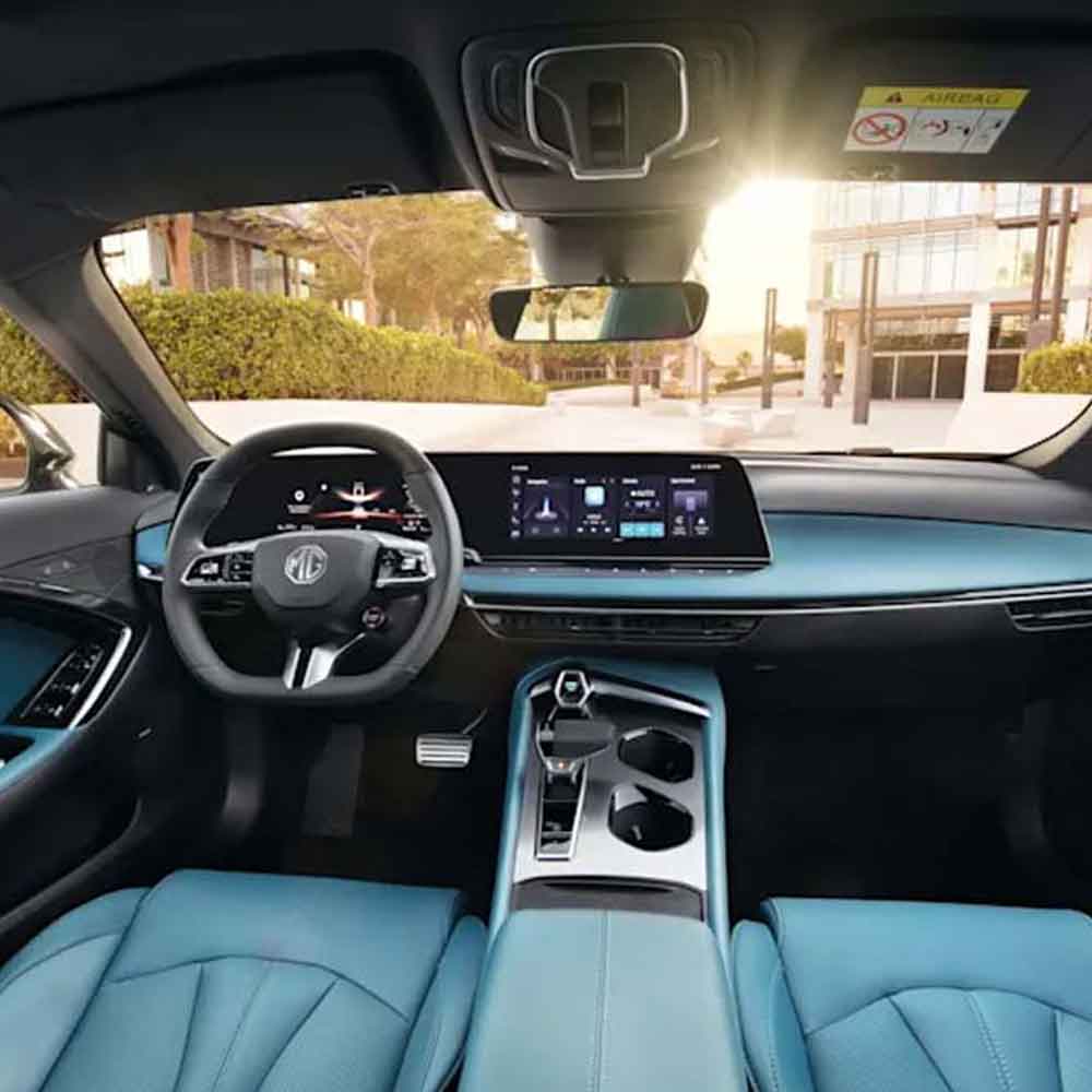 Interior of a car with blue seats and a modern dashboard, with sunlight streaming in through the windshield.