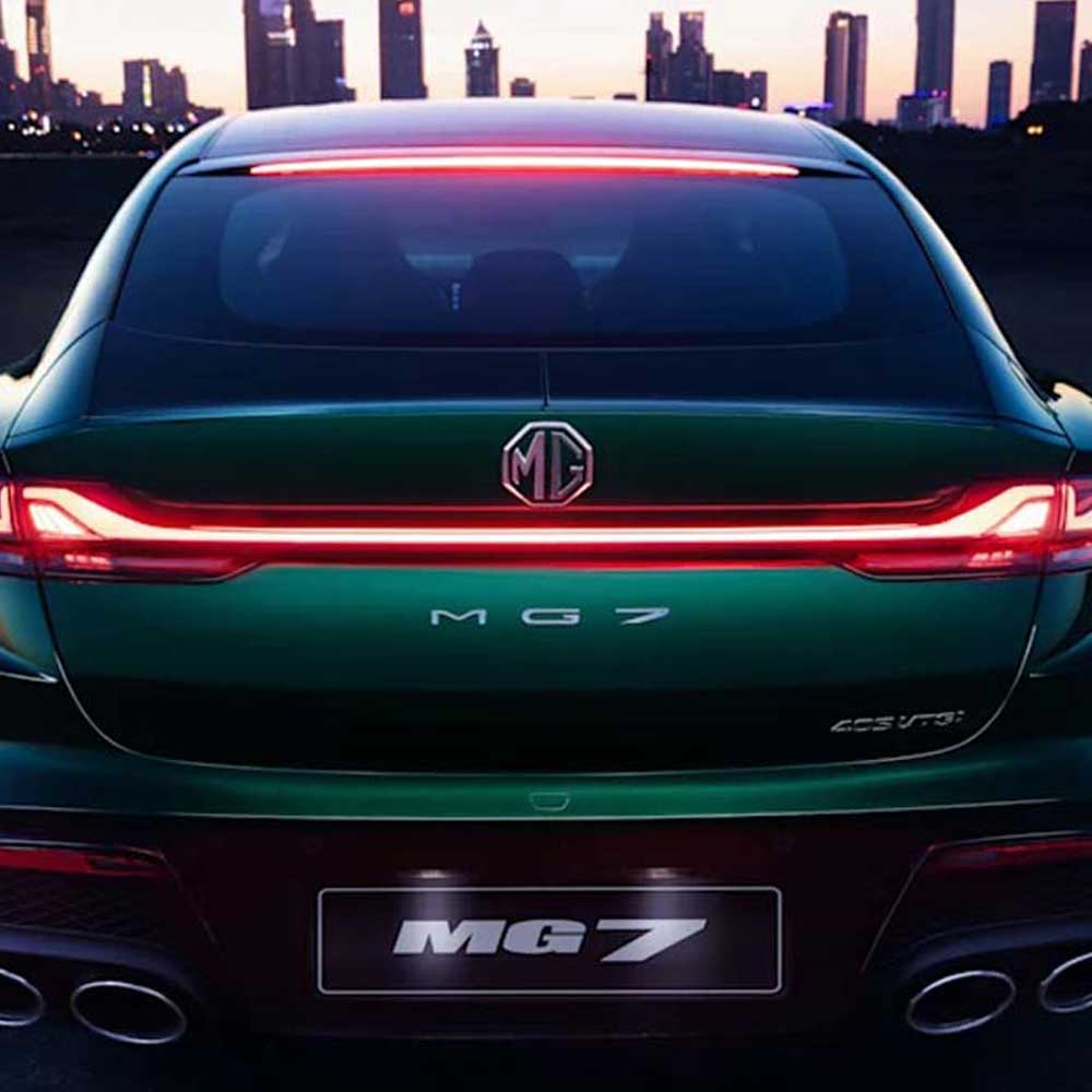 The rear view of a green MG7 car with illuminated taillights, set against a city skyline at dusk.