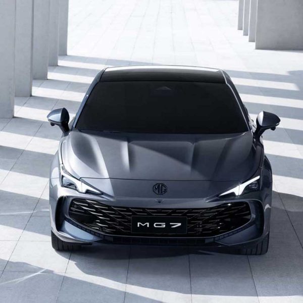 Front view of a gray MG7 car parked in a modern, sunlit architectural space with columns and shadows.