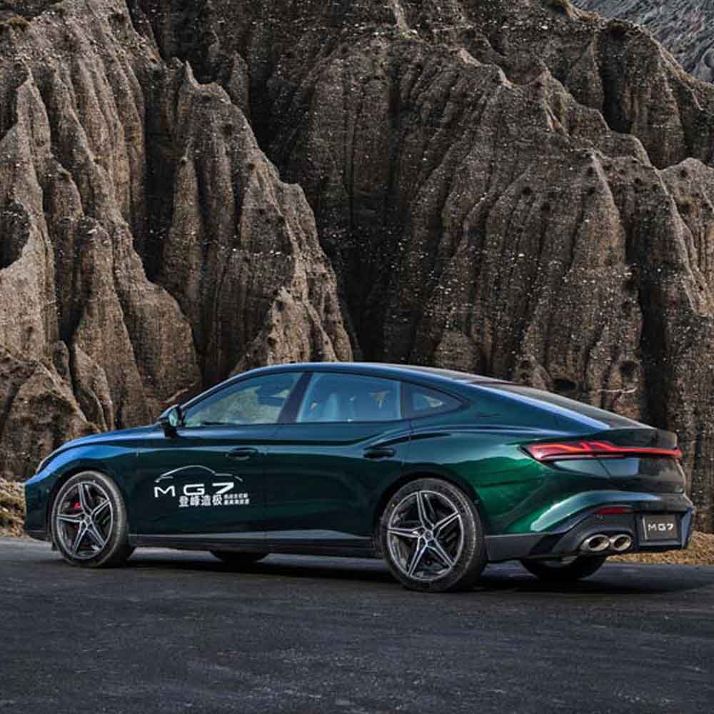 MG7 2025 1.5T 300DCT Luxury Edition product gallery image 2 A dark green MG7 car parked on a road with rugged rock formations in the background.