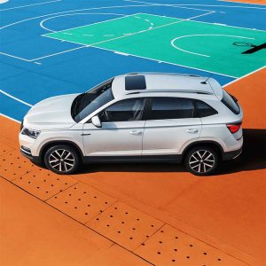 SKODA KAMIQ 2025 1.5L Auto Comfort Edition Profile Shot White SUV parked on a colorful sports court.