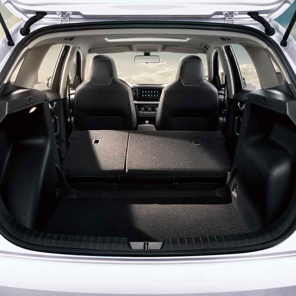 Car's cargo area with folded rear seats, showing spacious storage space.