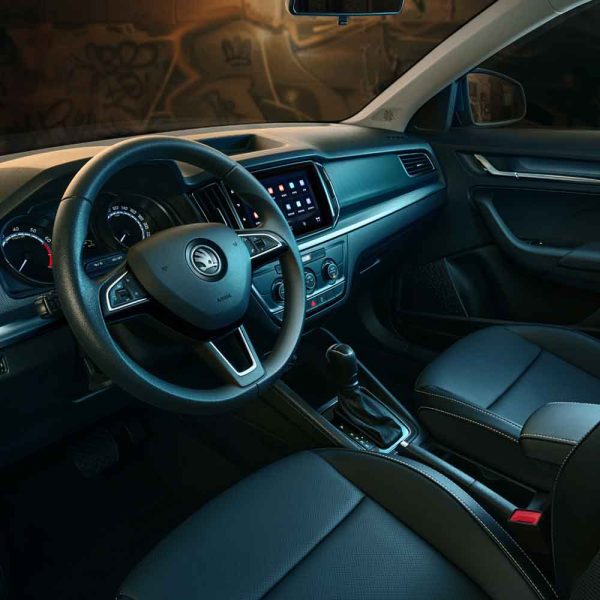 Skoda car's interior featuring steering wheel, infotainment screen, and leather seats.