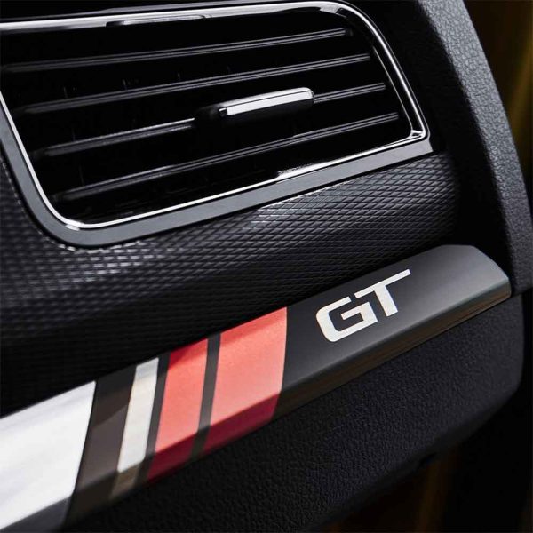 Close - up of car interior trim with "GT" badge and colorful stripes.