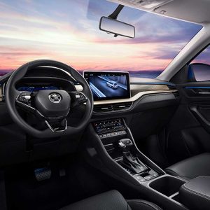 SKODA KODIAQ 2025 TSI330 5-Seater FWD Luxury Edition gallery image Driver's Compartment Interior of a Skoda car showing the steering wheel, infotainment screen with navigation, and dashboard, with a sunset sky visible through the windshield.
