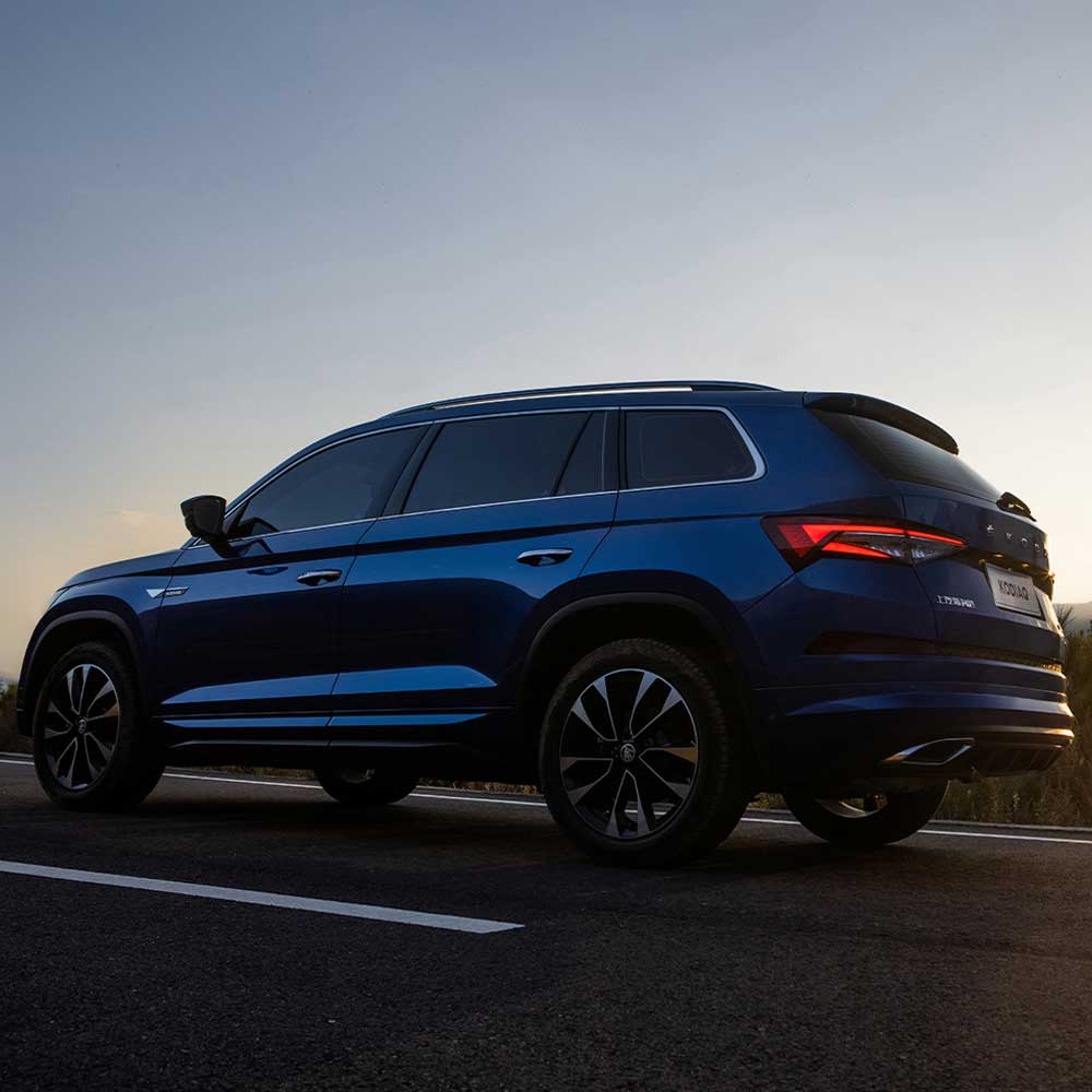 SKODA KODIAQ 2025 TSI330 5-Seater FWD Luxury Edition gallery image Profile Shot A blue SUV (Skoda Kodiaq) driving on a road at dusk.