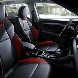 Interior of a car featuring black and red leather seats and a gear shift.