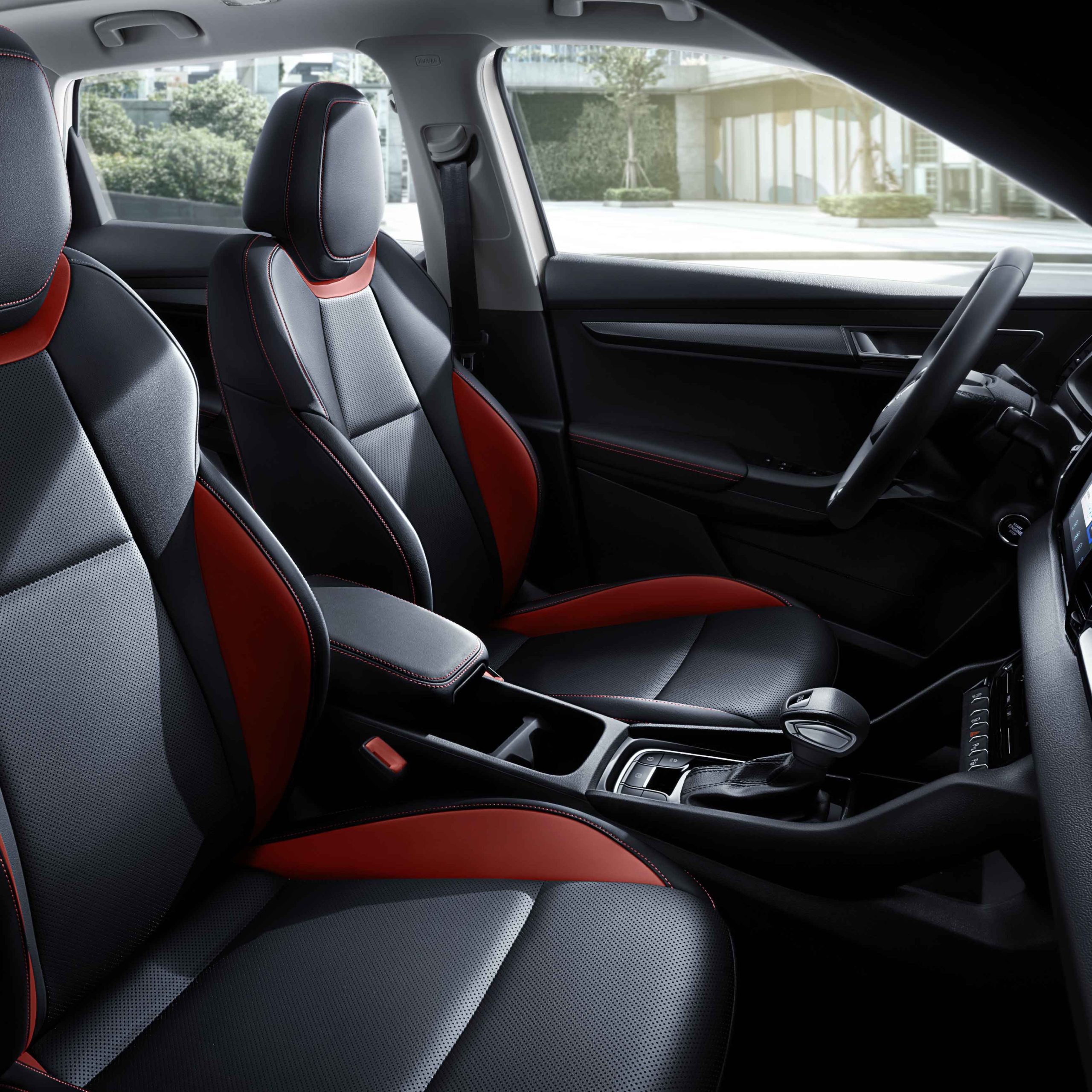 Interior of a car featuring black and red leather seats and a gear shift.