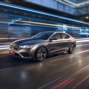 A silver Skoda Octavia Pro car driving on a road with dynamic light trails in the background.
