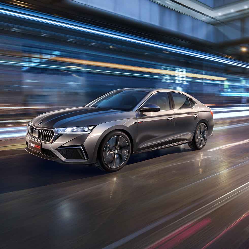 A silver Skoda Octavia Pro car driving on a road with dynamic light trails in the background.