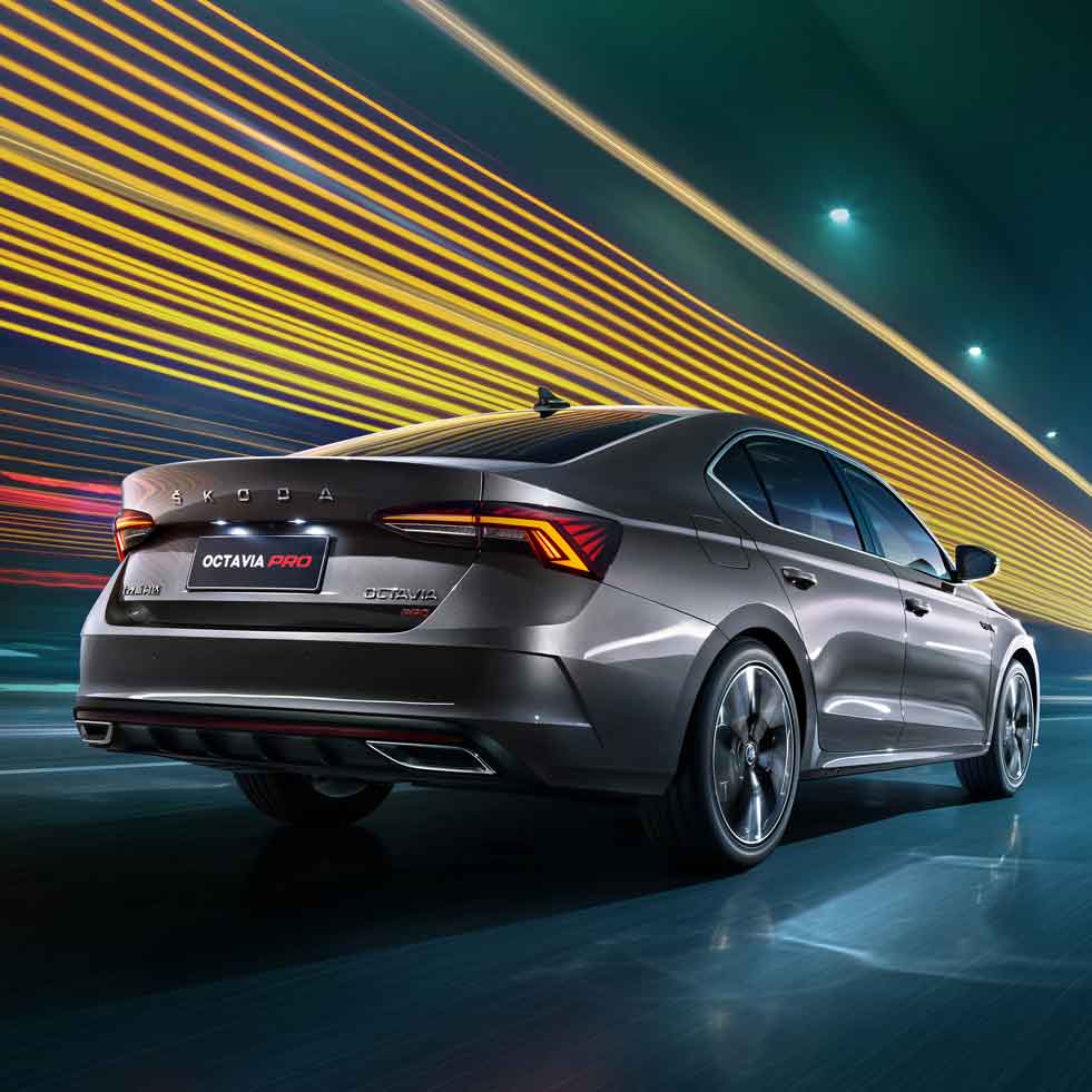 Rear view of a Skoda Octavia Pro car in motion, with dynamic light trails in the background.