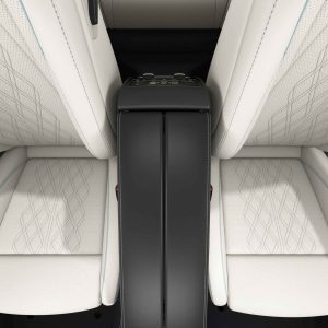 Interior view of a car's front seats with a central console in between. The seats are upholstered in white leather with a diamond - pattern stitching, and the console features control buttons.