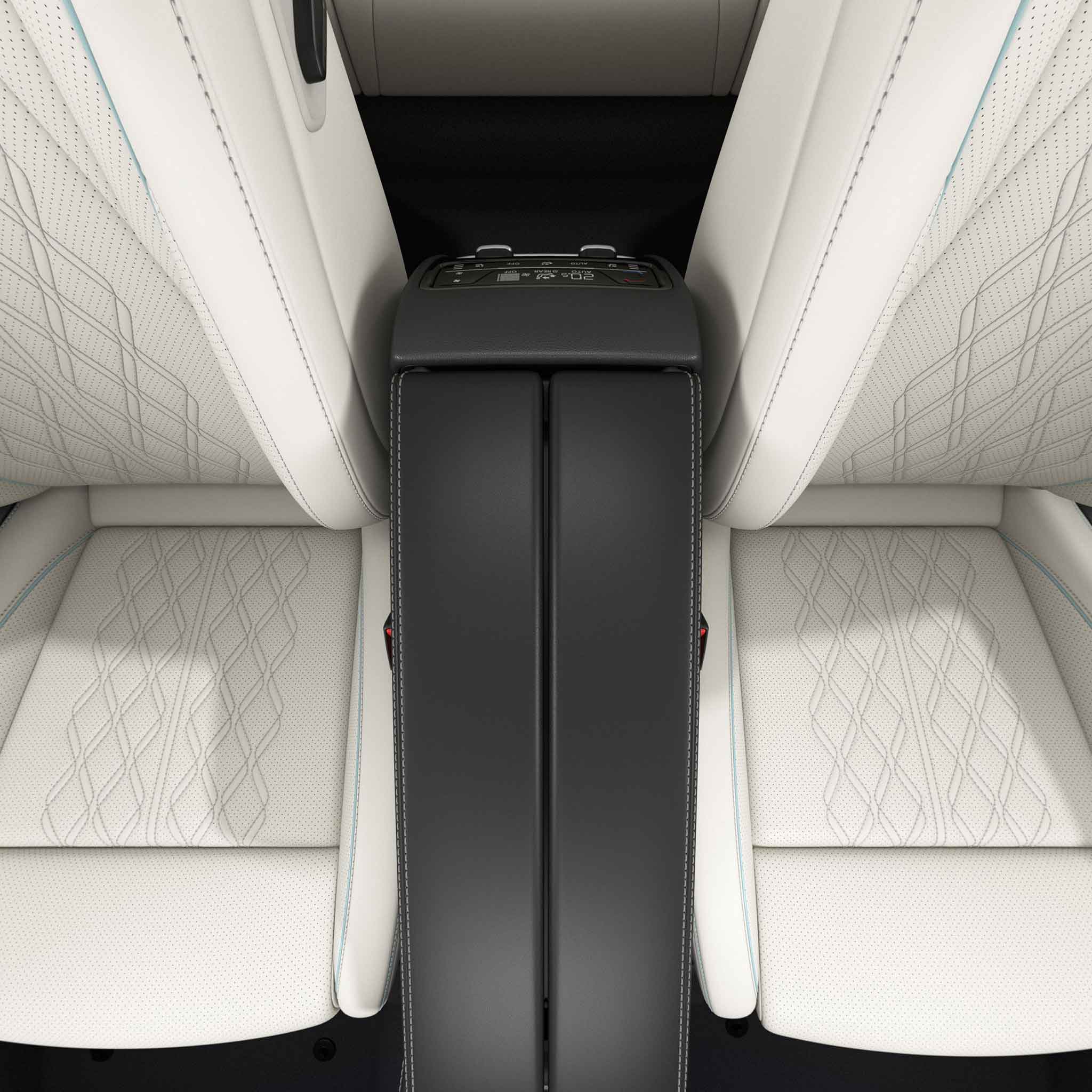 Interior view of a car's front seats with a central console in between. The seats are upholstered in white leather with a diamond - pattern stitching, and the console features control buttons.