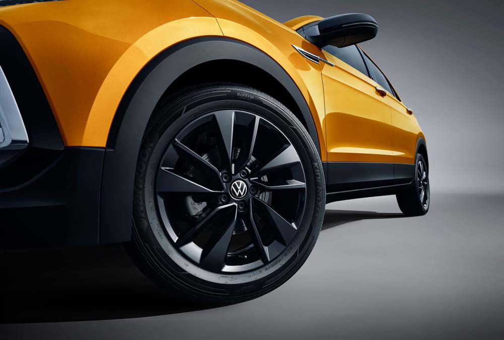 Close - up of a yellow Volkswagen car's wheel and tire.
