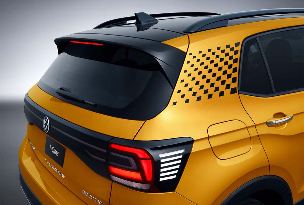 Rear view of a yellow Volkswagen T - Cross with a checkered pattern on the side.