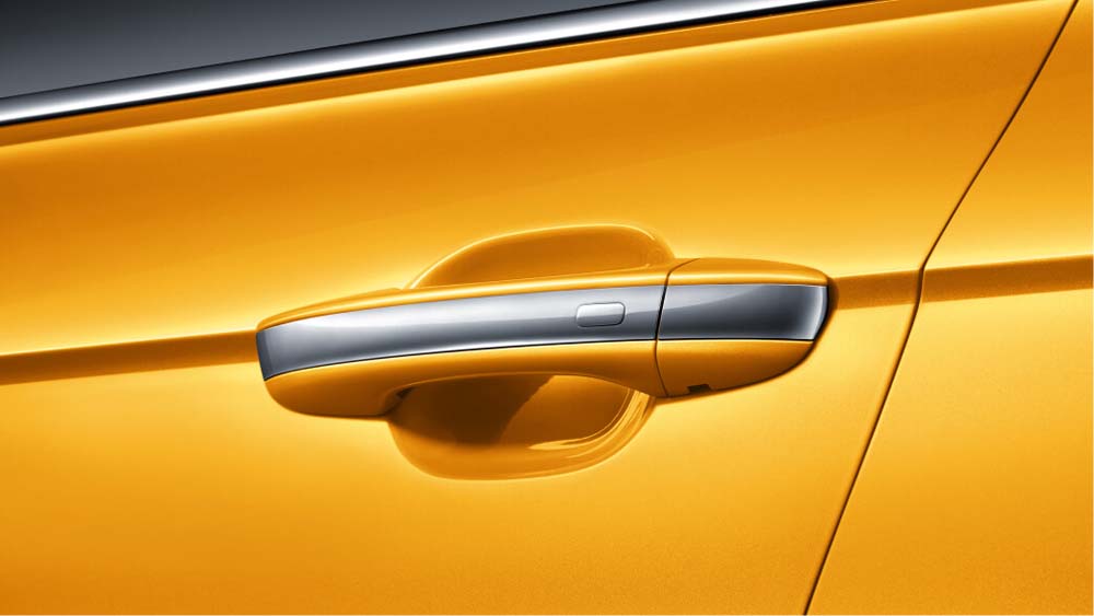 Close - up of a car door handle on an orange vehicle.
