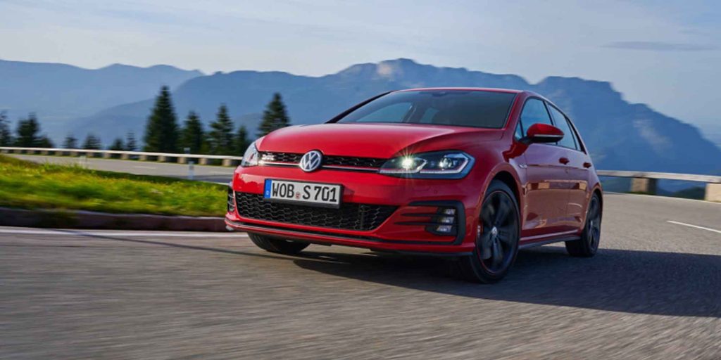 Red VW Golf 7 drives round a bend
