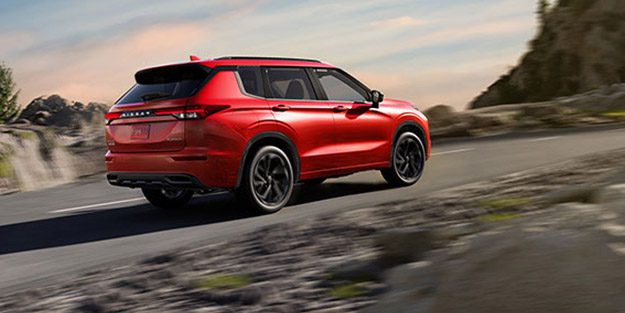 2026 Nissan Rogue PHEV rear view driving on mountain road