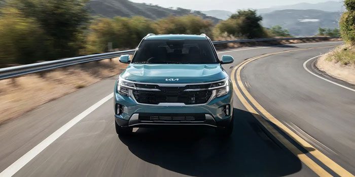 A blue 2025 Kia Seltos driving on the road