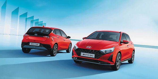 Front view of a blue Hyundai i20 sedan driving on a city road