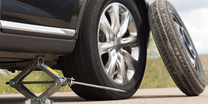 Using a jack to lift a car to change a tire