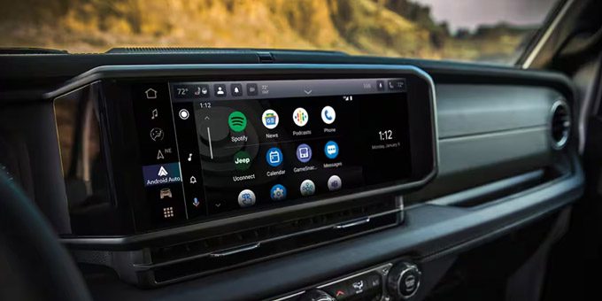 Display A close-up of the Uconnect touchscreen in the 2025 Jeep Wrangler displaying a series of Android Auto selections and the current date and time