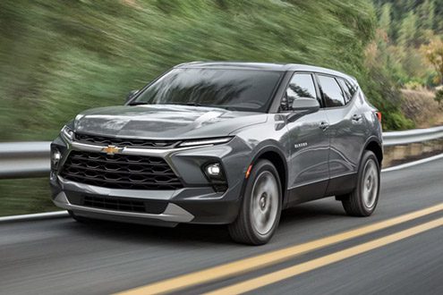 Gray 2026 Chevy Blazer Driving Swiftly on a Treelined Road