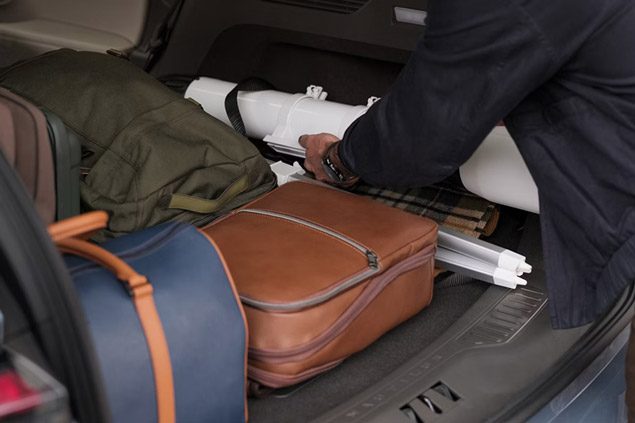 A person loads the rear cargo area of a 2026 Lincoln Nautilus with the rear seat folded flat